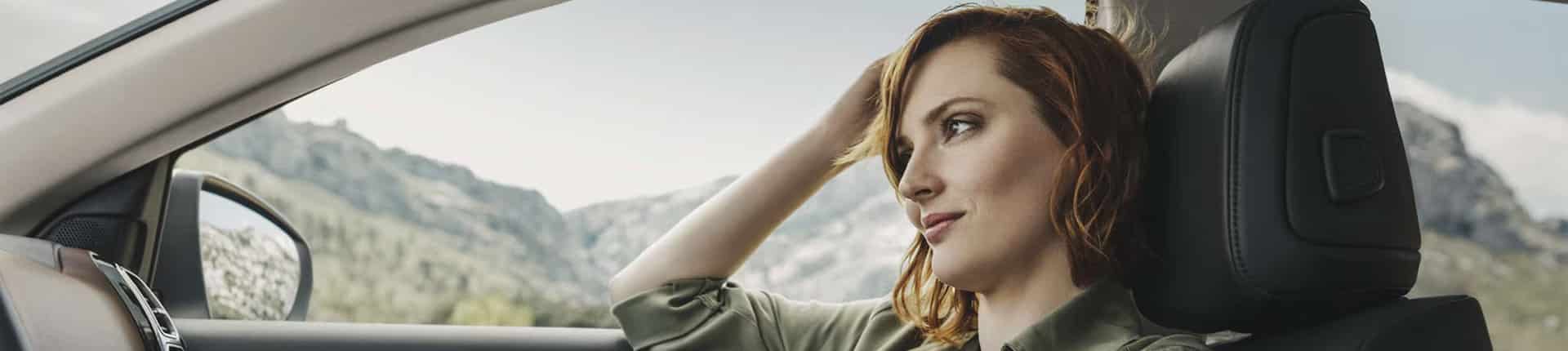 jeune femme coté passage dans véhicule Citroën qui regarde vers l'horizon