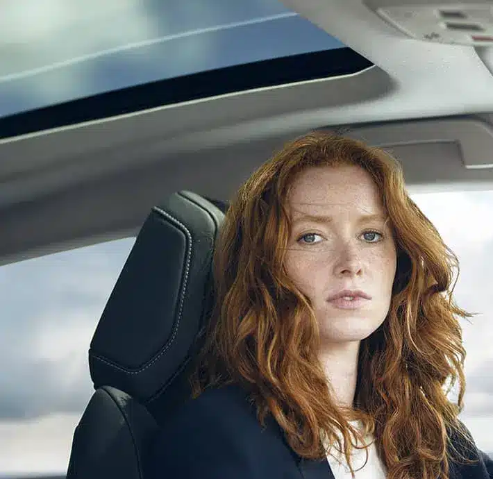 jeune dame rousse dans vehicule berline confortable citroen valence qui regarde en face de l'objectif